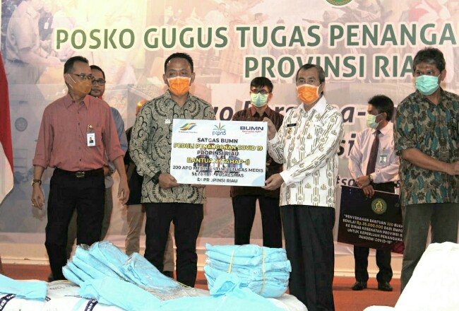 Direktur Utama PTPN V, Jatmiko K Santosa secara simbolis menyerahkan APD kepada Gubernur Riau, H Syamsuar.