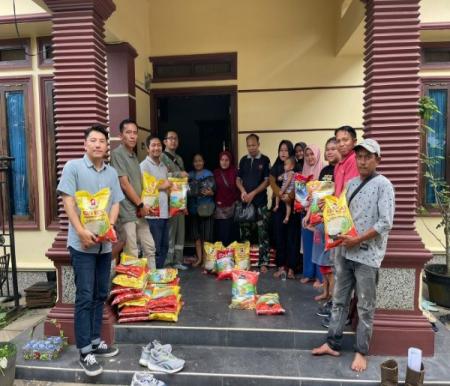 Perwakilan manajemen EMP Bentu Limited menyerahkan bantuan sembako kepada warga Kota Pangkalan Kerinci, Pelalawan (foto/ist)