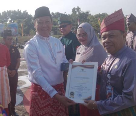 Wakil Ketua DPRD, Syafrizal memberikan piagam penghargaan Terinovatif III yang diterima langsung Kasatpol PP dan Damkar Pelalawan, Tengku Junaidi (foto/andi)
