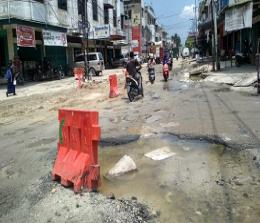 Air PDAM menggenangi ruas Jalan Cempaka akibat kebocoran pipa sambungan.