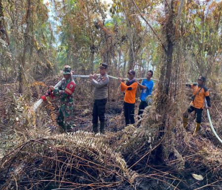 Anggota BPBD Kepulauan Meranti bersama petugas gabungan TNI Polri dan MPA melakukan pendinginan terhadap lahan terbakar