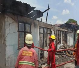 Petugas Damkar melakukan pemadaman setelah 5 rumah di Jalan HR Soebrantas Pekanbaru ludes terbakar.(foto: antaranews.com)