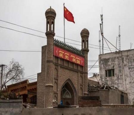 ilustras: Bendera China berkibar di atas masjid yang sudah ditutup pihak berwenang di Kota Tua Kashga, China. Sumber : Getty Images/Kevin Frayer