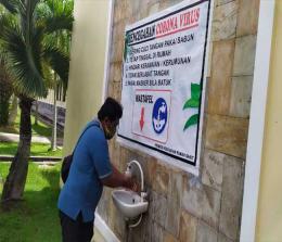 Salah seorang wartawan di Kepulauan Meranti tetap melakukan penerapan protokol kesehatan saat akan meliput,mencuci tangan dan memakai masker