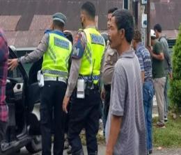 Petugas Satlantas Polresta Pekanbaru di lokasi kecelakaan Sigra maut.(foto: int)