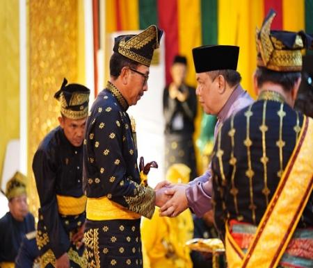 Pj Gubri, SF Hariyanto mengucapkan selamat ke Kajati Riau, Akmal Abbas yang dianugerahi gelar Datuk Seri Lela Setia Junjungan Negeri dari LAMR (foto/Yuni)
