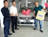 Branch Manager Suzuki RJC Arengka, Pekanbaru, Syamsul foto bersama konsumen yang membeli Ertiga