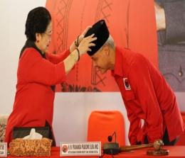 Ketum PDIP, Megawati memakaikan kopiah hitam kepada Ganjar Pranowo.(foto: int)