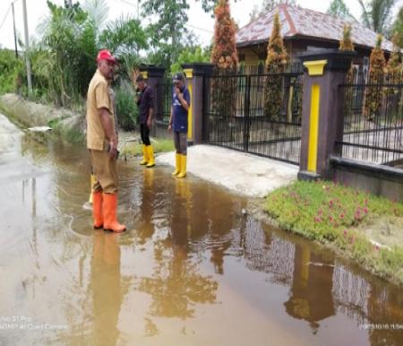 Kepala DLH Rohil, Suwandi meninjau lokasi banjir di Jalan Pelabuhan Baru Rohil.(foto: afrizal/halloriau.com)