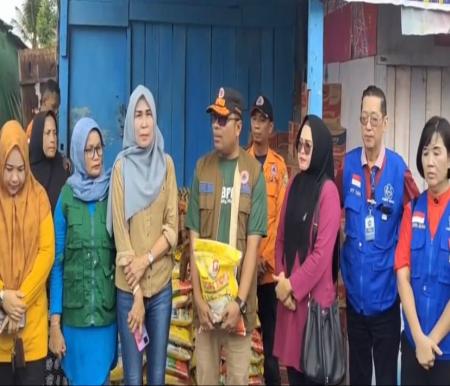 Kalaksa BPBD Kota Pekanbaru Zarman Candra menerima bantuan sembakao dari PSMTI Riau bagi warga yang terdampak banjir di Kecamatan Rumbai (foto/int)