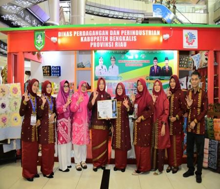 Ketua Dekranasda Bengkalis, Siti Aisyah menerima penghargaan Stand Terbaik I Bidang Informasi Perdagangan di Pameran Explore South Sumatera (foto/zul)