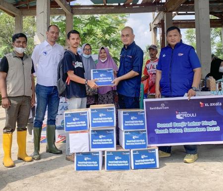 Penyerahkan donasi dari XL Axiata Peduli kepada warga korban bencana banjir lahar dingin di Posko Peduli Bencana, Kecamatan Limo Kaum, Minggu (19/5/2024). 