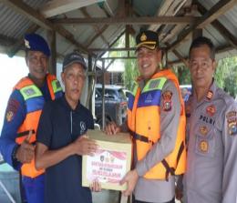 Kapolres Pelalawan, AKBP Suwinto menyerahkan bantuan paket sembako untuk nelayan.(foto: andi/halloriau.com)