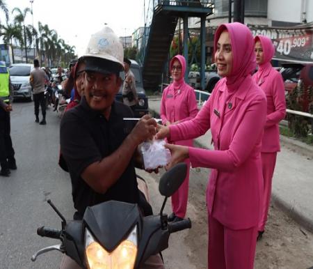 Ketua Bhayangkari cabang Pelalawan, Yetti Suwinto saat membagikan takjil di Jalan Lintas Timur Pangkalan Kerinci.(foto: andi/halloriau.com)