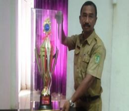 Kabid Kepemudaan dan Olahraga Disparpora Rohil, Khairullah menunjukkan thropy juara umum II Popda XV Riau.