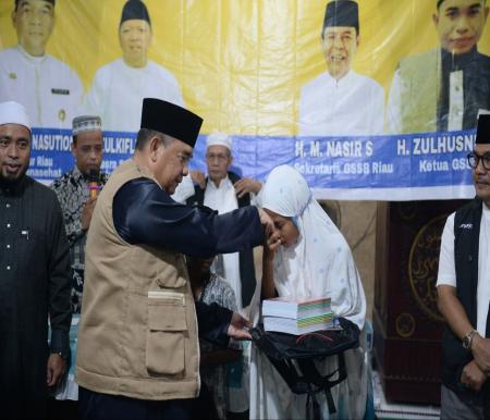 Gubernur Riau, Edy Natar juga menyerahkan bantuan untuk anak sekolah dasar berupa buku dan tas (foto/int)