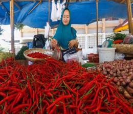 Ilustrasi: Neli memperlihatkan cabai merah yang dijualnya di pasar Jalan Teratai Pekanbaru 