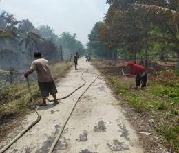 Karhutla di Tanjung Peranap sudah mendekati tepi jalan, terlihat beberapa warga berusaha memadamkan api dengan alat seadanya
