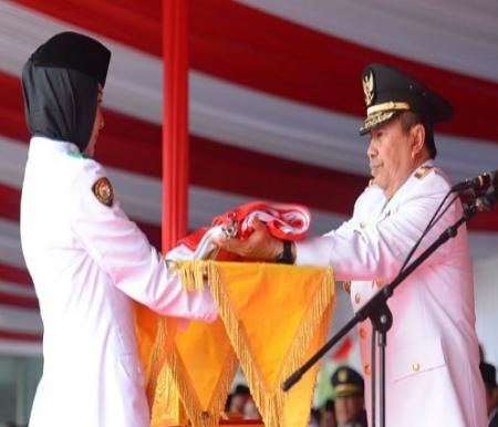 Gubernur Riau, Syamsuar menyerahkan bendera merah putih kepada pembawa baki Paskibra Riau saat upacara HUT ke-78 RI di Kantor Gubernur Riau.(foto: rivo/halloriau.com)