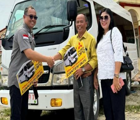 Doni Ardila selaku Sales Manager PT DIPO menyerahkan kunci sekaligus unit Canter Bus.(foto: budy/halloriau.com)