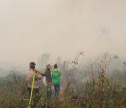 Tampak tim memadamkan api di lokasi lahan terbakar.