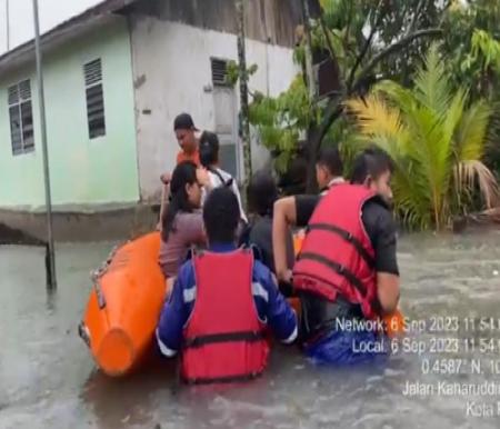Petugas BPBD Pekanbaru mengevakuasi warga yang rumahnya terendam banjir beberapa waktu lalu (foto/int)