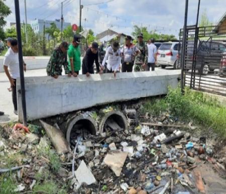 Pj Walikota Pekanbaru, Muflihun saat meninjau drainase yang tersumbat akibat sampah di Jalan Arifin Ahmad Pekanbaru.(foto: pgi)