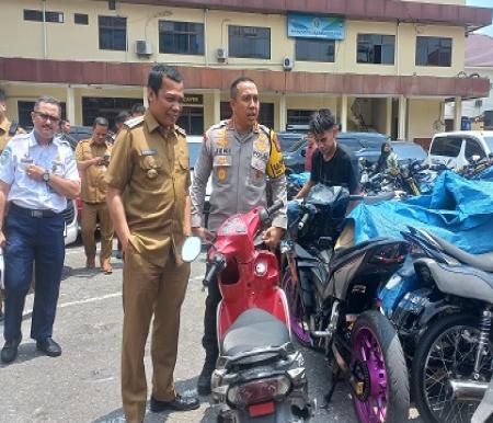 Pj Wako Pekanbaru, Muflihun bersama Kapolresta Kombes Jeki Rahmat mengecek motor yang disita akibat aksi balap liar (foto/dini)