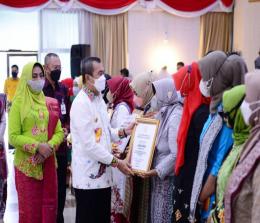 Gubernur Syamsuar saat menyerahkan penghargaan kepada 12 perempuan dari 12 daerah di Riau.