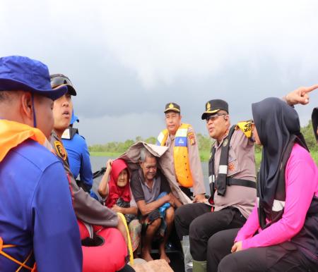 Kapolres Pelalawan, AKBP Suwinto evaluasi lansia yang terjebak banjir pakai perahu (foto/andi)