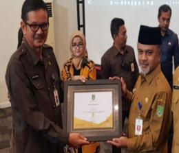 Sekdako Dumai Indra Gunawan memberikan penghargaan SAKIP 2022 kepada Kadiskes Dumai, dr Syaiful.(foto: bambang/halloriau.com)