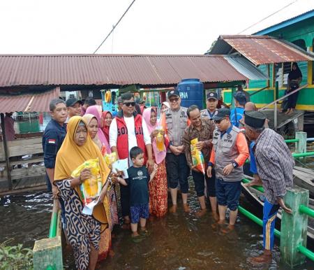 Bupati Pelalawan, Zukri menyerahkan bantuan kepada korban banjir. (foto/andi)