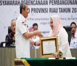 Bupati Bengkalis, Kasmarni menerima penghargaan yang diserahkan Gubernur Riau, Syamsuar.(foto: zulkarnaen/halloriau.com)