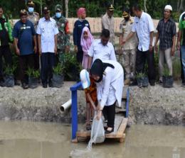 Bupati Inhu Rezita Meylani Yopi menebar bibit ikan nila di Desa Kuantan Tenang