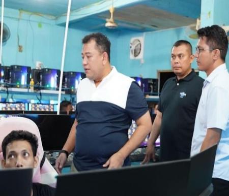 Polisi saat menggerebek satu dari dua markas judi online di Kota Dumai, Riau. (Dok Polda Riau)