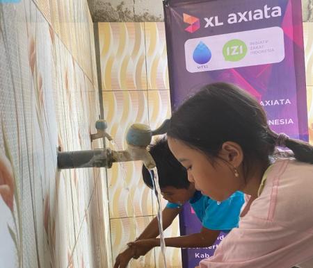 Seorang warga sedang memanfaatkan bantuan sarana air bersih dari karyawan XL Axiata di Dusun Kertasari, Brebes (foto/ist)