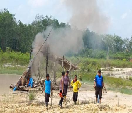 Aparat Polsek Pangean membakar rakit PETI yang digunakan pelaku penambang emas ilegal di Kuansing.(foto: detik.com)