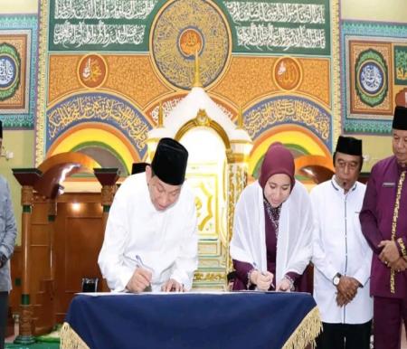 Bupati Inhu Rezita menerima hibah pengelolaan Masjid Raya Ar Rahman dari Datok Seri H R Marjohan Yusuf (foto/andri)
