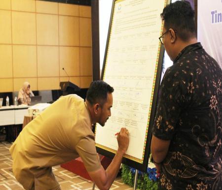 Kadiskominfotiksan Pekanbaru, Raja Hendra Saputra saat penandatanganan kerjasama dengan Ombudsman RI perwakilan Riau.(foto: pgi)