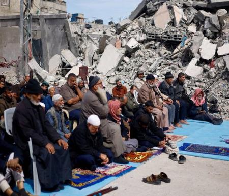 Warga Palestina menghadiri salat Jumat di dekat reruntuhan masjid yang hancur akibat serangan Israel, di tengah konflik yang sedang berlangsung antara Israel dan Hamas, di Rafah di selatan Jalur Gaza, Jumat (1/3/2024). Foto: Mohammed Salem/REUTERS