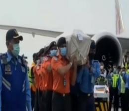 Petugas Bandara Soetta membawa peti jenazah Eril dari pesawat menuju mobil ambulans