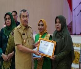 Gubernur Riau, Syamsuar didampingi Ketua TP PKK Riau, Misnarni Syamsuar saat menyerahkan penghargaan pemenang lomba hari ibu.(foto: mcr)