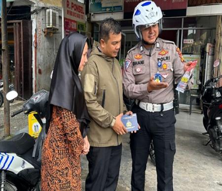 Petugas Ditlantas Polda Riau menyerahkan BPKB kepada pemilik.(foto: istimewa)