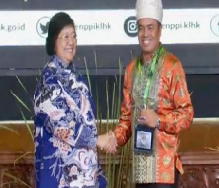 Mentri KLHK Siti Nurbaya Bakar serahkan penghargaan proklim utama ke kepala Desa Delik, Saiman.(foto: istimewa)