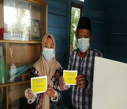 Pasangan suami-istri, Sugianto dan Sunarsih saat memasukkan surat suara dalam kotak, keduanya juga merupakan kontestan yang bertarung di Pilkades Desa Gogok Darussalam