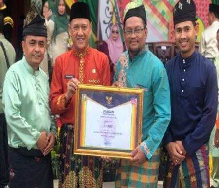 Pj Bupati Kampar, Hambali SE MH menyerahkan penghargaan kepada Manajer SHR RAPP wilayah Kabupaten Kampar, R Elwan Jumandri SH MH.(foto: istimewa)