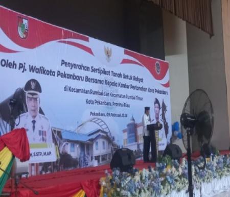 Pj Walikota Pekanbaru, Muflihun saat penyerahan sertifikat PTSL.(foto: mg2/halloriau.com)