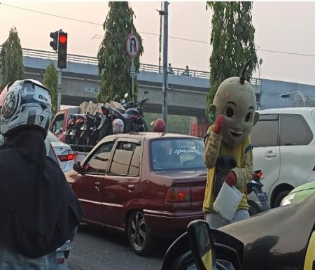 Gepeng secara terang-terangan meminta kepada pengendara yang berhenti di persimpangan jalan di Pekanbaru (foto/rahmat)