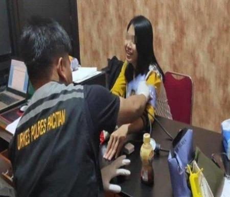 SWK, seorang janda yang berprofesi biduan dangdut ditangkap kasus buang bayi ini tersenyum saat diperiksa polisi (foto/int)
