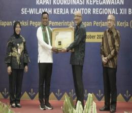 Bupati Pelalawan, Zukri Misran menerima penghargaan untuk BKPSDM Pelalawan dari BKN Pusat.(foto: andi/halloriau.com)